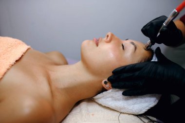 Kozmetoloji kliniğinde, profesyonel bir kozmetik uzmanı bir hidroyüz ameliyatı gerçekleştirir. Bir uzman yüz derisindeki gözenekleri temizler. Kaplıcada gençleştirme ve su kaybı