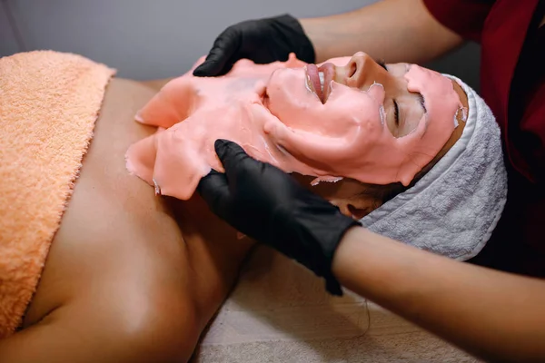 Uma Menina Morena Faz Procedimentos Salão Spa Uma Máscara Rosa — Fotografia de Stock