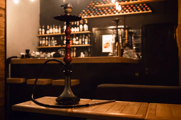 Hookah on the table in the club against the background of the bar. Traditional east arabic concept of rest with hookah