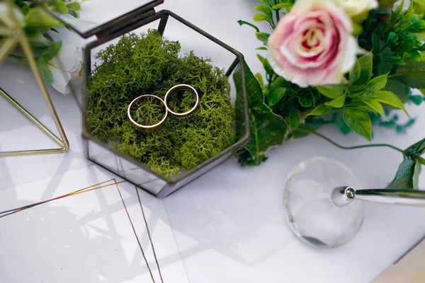 婚宴桌上摆满了鲜花和新婚夫妇的金戒指 放在一个玻璃盒里 婚礼当天 为新郎新娘的会面做准备 文件的自由篇幅 — 图库照片