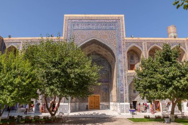 Avludan Ulugh Beg medrese görünümü. Ağaçları ile medrese avluda. Registan Meydanı Semerkant'a medrese içinde. Eski medrese Özbekistan'a. Orta Asya'daki eski bir şehirde güneşli yaz gün.
