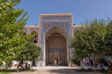 Avludan Ulugh Beg medrese görünümü. Ağaçları ile medrese avluda. Registan Meydanı Semerkant'a medrese içinde. Eski medrese Özbekistan'a. Orta Asya'daki eski bir şehirde güneşli yaz gün