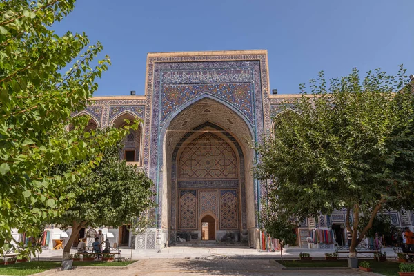 Avludan Ulugh Beg medrese görünümü. Ağaçları ile medrese avluda. Registan Meydanı Semerkant'a medrese içinde. Eski medrese Özbekistan'a. Orta Asya'daki eski bir şehirde güneşli yaz gün
