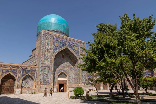 Avludan medrese Tillya-Kari görünümü. Ağaçları ile medrese avluda. Registan Meydanı Semerkant'a medrese içinde. Eski medrese Özbekistan'a. Orta Asya'daki eski bir şehirde güneşli yaz gün.