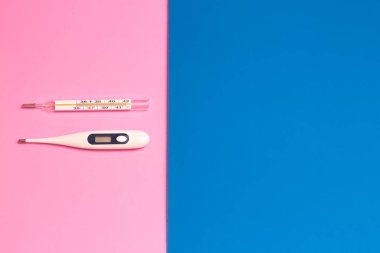 iki termometre, bir civa ve diğeri pembe ve mavi arka planda (arkaplan)