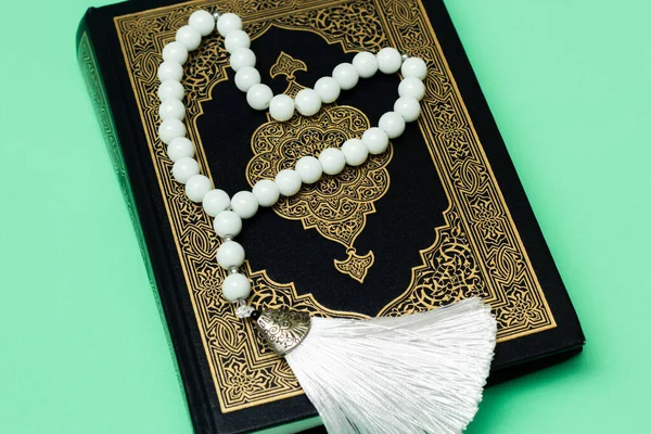古兰经和白色的穆斯林念珠 绿色背景 — 图库照片