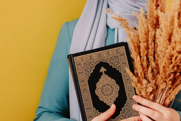 Мусульманка Платке Держит Коран Руках Розовом Фоне — стоковое фото