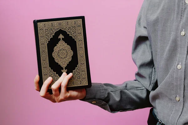 Der Kerl Hält Den Heiligen Koran Der Hand Auf Rosa — Stockfoto