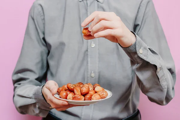 Adamın elinde tuttuğu tarihler (pembe arka planda). Ramazan