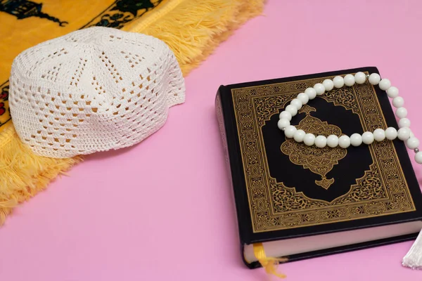 古兰经 头戴草帽 有穆斯林念珠 有粉色背景的祈祷毯 — 图库照片