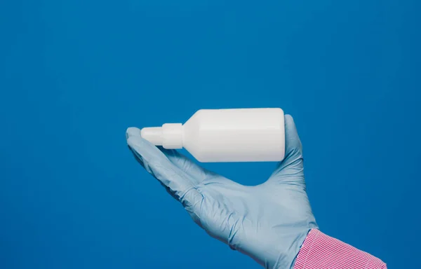 Egy Fickó Orvosi Kesztyűben Tart Egy Fehér Üveget Kék Háttér — Stock Fotó