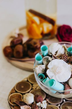 Su portakalları ve tarçınlı süs. Tarihler. Gül çiçeği. Kurumuş çiçekli ve yapraklı bir vazo. İftar, güneş ışığı, hurma ve su. Ramazan