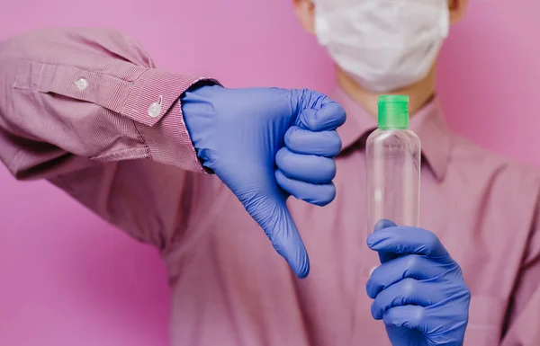 Egy Fickó Orvosi Kesztyűben Tart Egy Üres Fertőtlenítőt Hüvelykujj Rózsaszín — Stock Fotó