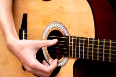 Adam gitar çalıyor. Yakın plan. Tahta gitar..