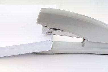 beyaz kağıt büyük bir yığın bir küçük ofis zımba, kavram arka plan yerleştirilir