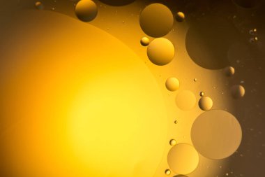 arasındaki etkileşimin su ve yağ, yağ kabarcıklar su yüzeyinde renkli irili ufaklı makro arka plan yumuşak defocusing ile soyut.