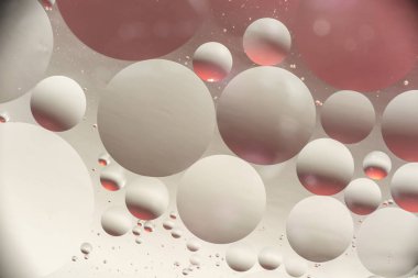 arasındaki etkileşimin su ve yağ, yağ kabarcıklar su yüzeyinde renkli irili ufaklı makro arka plan yumuşak defocusing ile soyut.