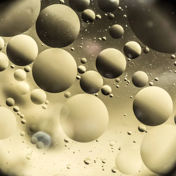 the interaction of water and oil, oil bubbles of various sizes on the water surface, colorful abstract macro background with soft defocusing