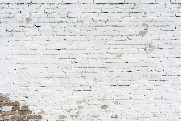 relief texture old brick wall painted with white paint, damages on the wall from the flow of water, architecture abstract background