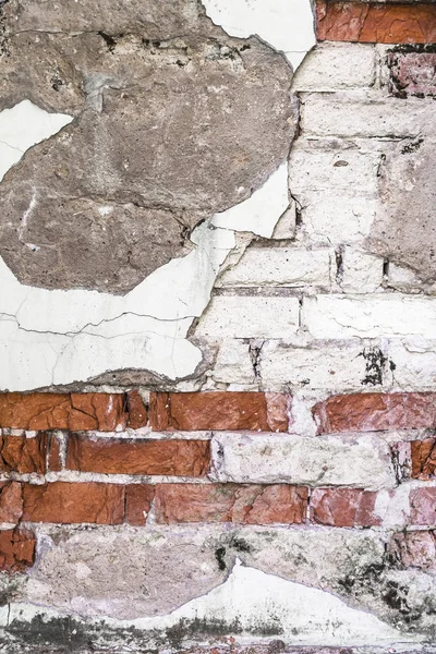 texture of a wall with destroyed bricks, crumbling plaster and damaged protective paint, architecture abstract background