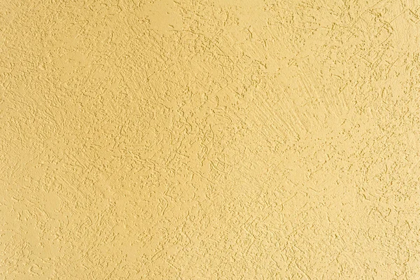The yellow texture of the surface of the wall covered with decorative plaster of the woodworm type, close-up architecture abstract background — Stock Image Yellow Texture Surface Wall Covered Decorative Plaster Woodworm Type Close Royalty Free Stock Photos