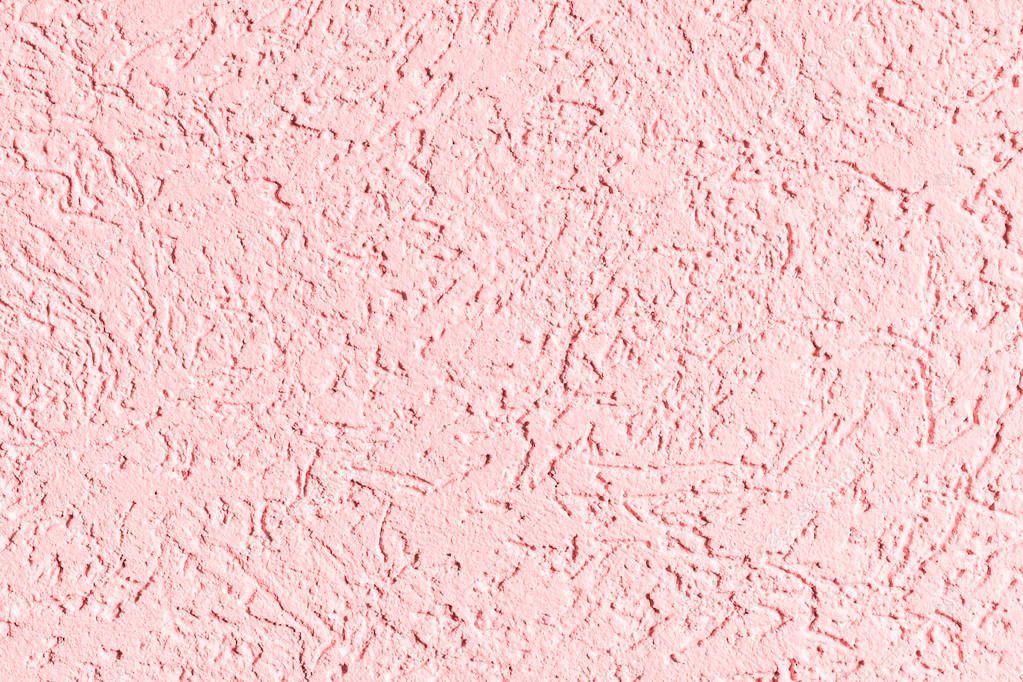 the pink texture of the surface of the wall covered with decorative plaster of the woodworm type, close-up architecture abstract background