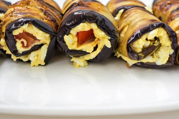 Rulo patlıcan peynir ve domates ile gelen beyaz tabakta yemek yakın çekim arka plan yalan