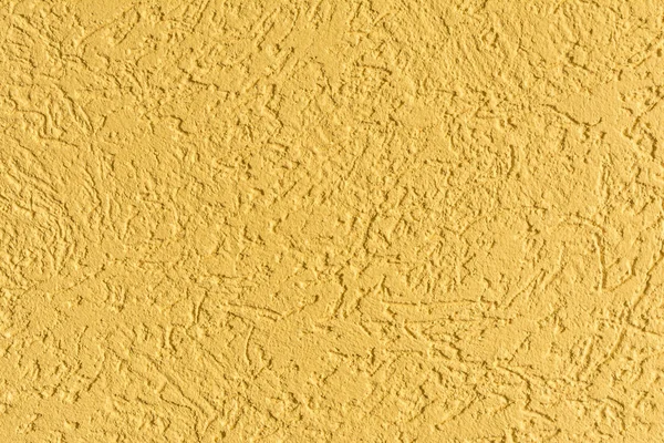 The yellow texture of the surface of the wall covered with decorative plaster of the woodworm type, close-up architecture abstract background — Stock Image Yellow Texture Surface Wall Covered Decorative Plaster Woodworm Type Close Royalty Free Stock Images