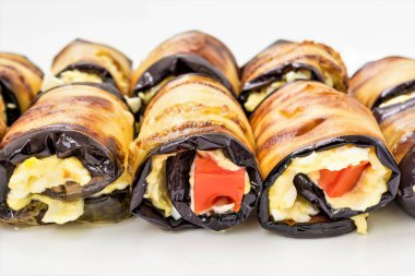 Bir beyaz tabak, yemek yakın çekim arka plan, seçici odak çerçeve merkezinde Patlıcan dolması peynir ve domates yalan dan rulo