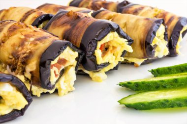 Peynir Rulo gelen Patlıcan dolması, domates ve dilimlenmiş yeşil salatalık yalan bir beyaz tabak, yemek yakın çekim arka plan, çerçeve merkezinde seçici odak