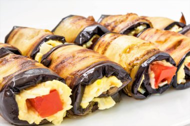 Bir beyaz tabak, yemek yakın çekim arka plan, seçici odak çerçeve merkezinde Patlıcan dolması peynir ve domates yalan dan rulo