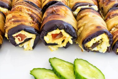 Peynir Rulo gelen Patlıcan dolması, domates ve dilimlenmiş yeşil salatalık yalan bir beyaz tabak, yemek yakın çekim arka plan, çerçeve merkezinde seçici odak