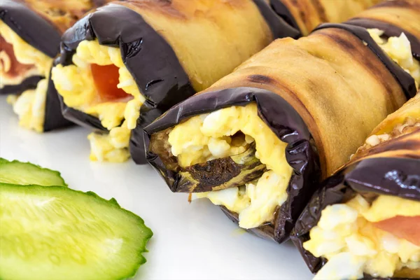 Peynir Rulo gelen Patlıcan dolması, domates ve dilimlenmiş yeşil salatalık yalan bir beyaz tabak, yemek yakın çekim arka plan, çerçeve merkezinde seçici odak