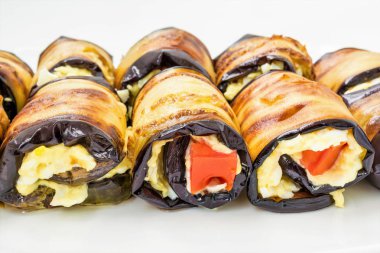 Bir beyaz tabak, yemek yakın çekim arka plan, seçici odak çerçeve merkezinde Patlıcan dolması peynir ve domates yalan dan rulo