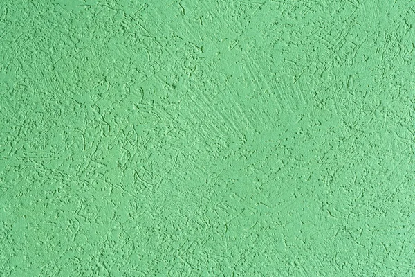 The green texture of the surface of the wall covered with decorative plaster of the woodworm type, close-up architecture abstract background — Stock Image Green Texture Surface Wall Covered Decorative Plaster Woodworm Type Close Stock Image