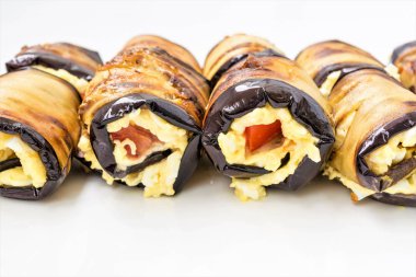 Bir beyaz tabak, yemek yakın çekim arka plan, seçici odak çerçeve merkezinde Patlıcan dolması peynir ve domates yalan dan rulo