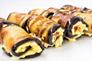 Bir beyaz tabak, yemek yakın çekim arka plan, seçici odak çerçeve merkezinde Patlıcan dolması peynir ve domates yalan dan rulo