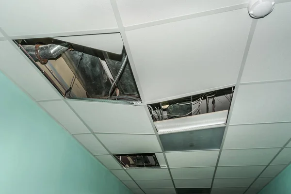 broken metal rails of a modern false ceiling with a built-in lamp in the old building