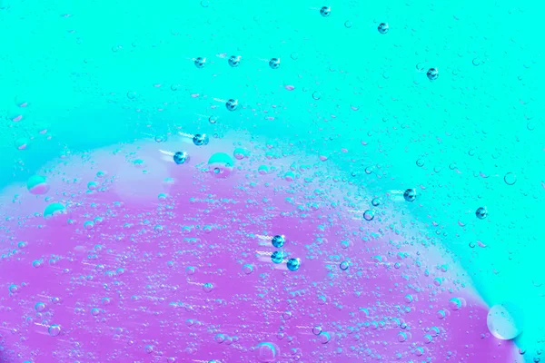 Water and oil bubble pink green background. Macro shot of beautiful water and oil bubble background , with small and big bubbles