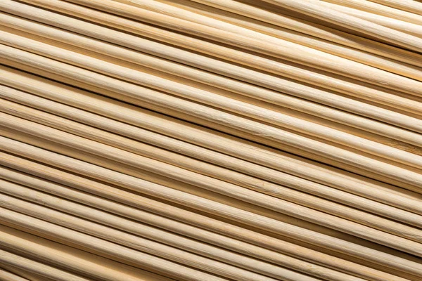 Round wooden sticks background. Wall Pattern. Close-up detail of round wooden sticks wall pattern