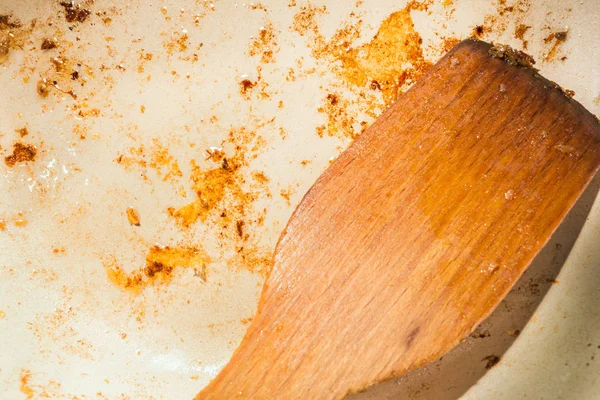 Це брудна жирна сковорода, дерев'яна шпатель на брудній сковороді, абстрактний фон — стокове фото