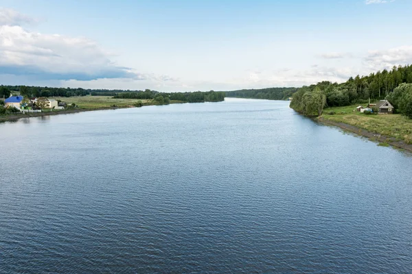 Hermosa vista del paisaje de la orilla de los ríos con casa y árboles. Durante el soleado día de verano en Bielorrusia — Foto de Stock
