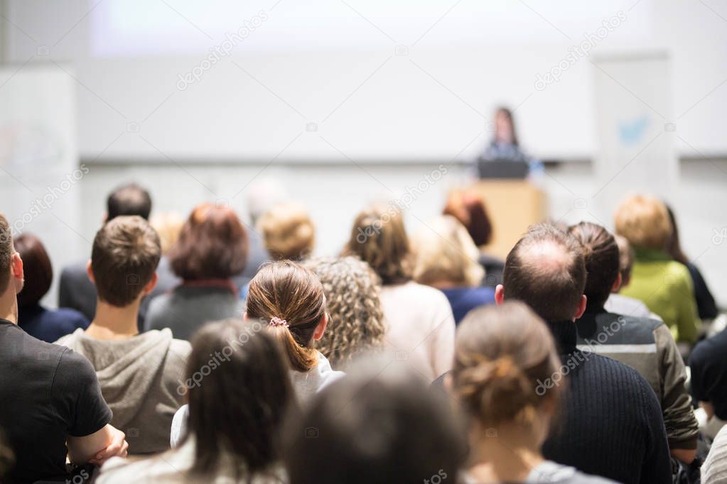 Woman giving presentation in lecture hall at university.