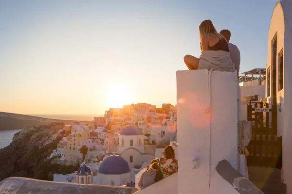 Couple watching sunrise and taking vacation photos at Santorini island, Greece. — Stock Photo, Image