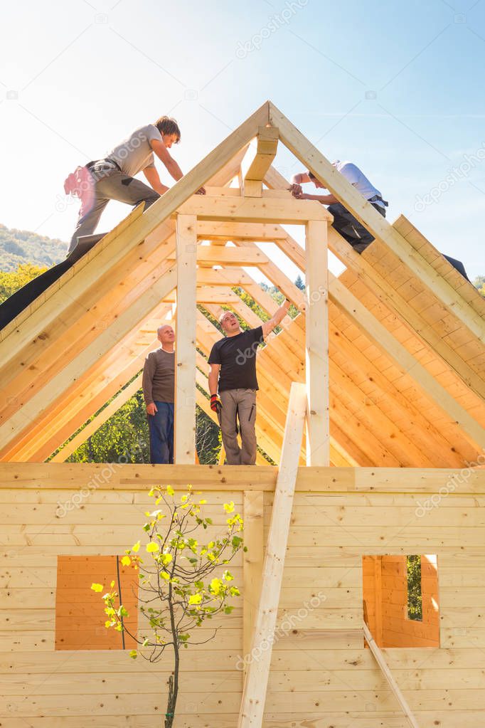 Builders at work with wooden roof construction.
