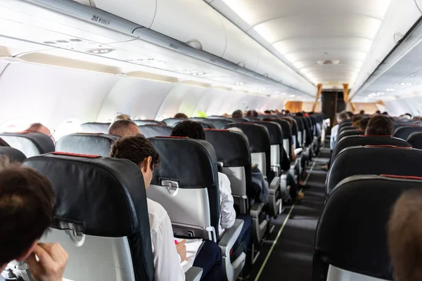 Interior de grande avião comercial com passageiros em seus assentos durante o voo . — Fotografia de Stock