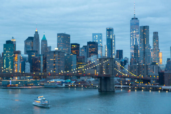 Out of focus image of Brooklyn Bridge and Lower Manhattan skyline at night seen from Manhattan bridge, New York city, USA.
