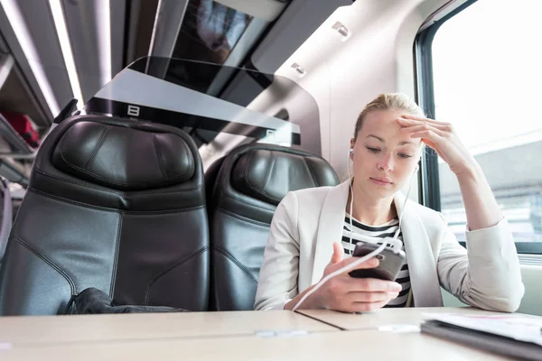 Empresária se comunicando no telefone celular enquanto viaja de trem. — Fotografia de Stock