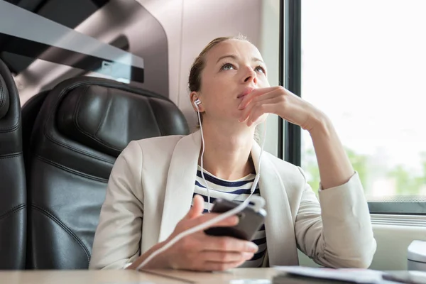 Thoughtful Businesswoman Communicating Cellphone Using Headphone Set While Traveling Train — Stock Photo, Image