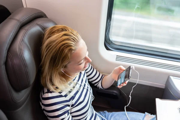 電車で旅行中の携帯電話の通信の女性. — ストック写真